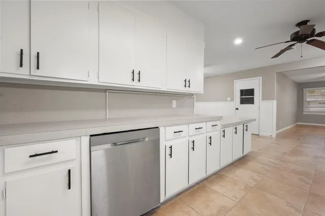a kitchen with granite countertop white cabinets and white appliances