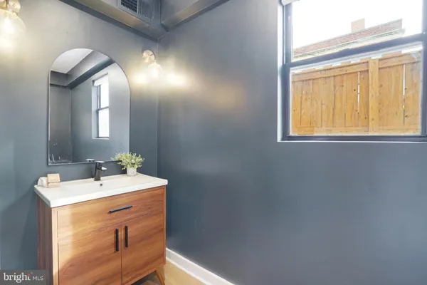 a bathroom with a sink mirror and vanity