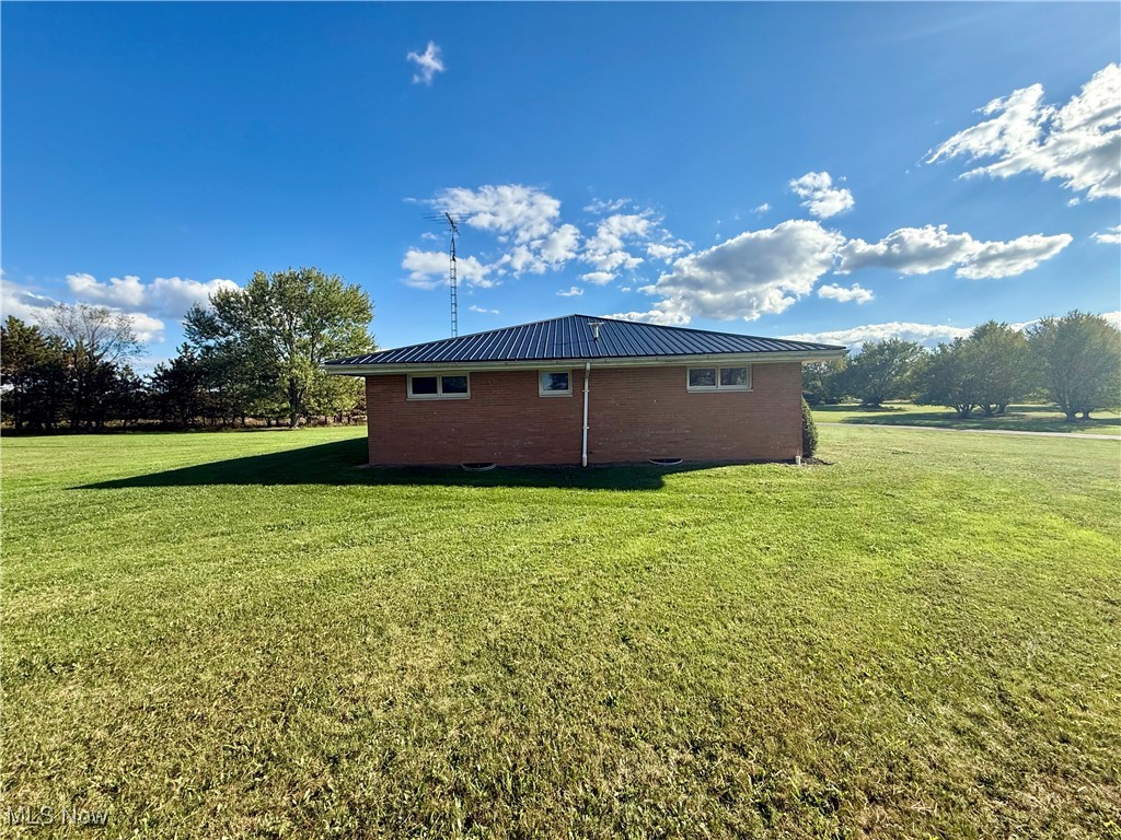 248 Scio Road Carrollton, OH 44615 - Photo 23 of 33 View of side of property with a metal roof, brick siding, and a yard