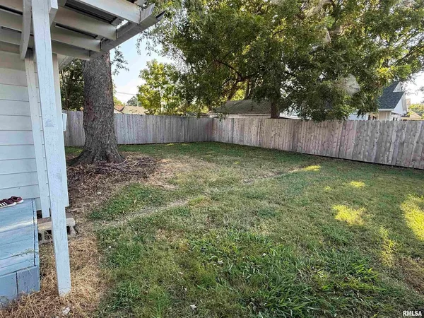 a view of a backyard with wooden fence