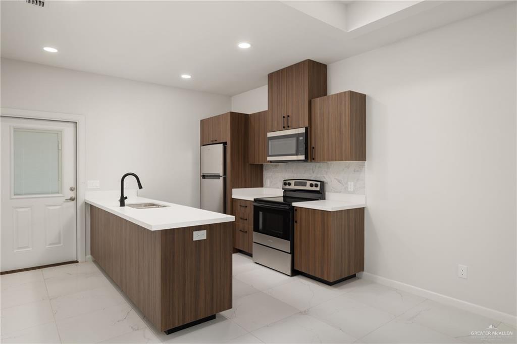 3513 Jessica Lane, Unit 2 Weslaco, TX 78599 - Photo 4 of 12 a kitchen with stainless steel appliances a sink stove and refrigerator
