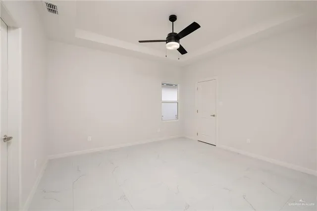 an empty room with a ceiling fan and window