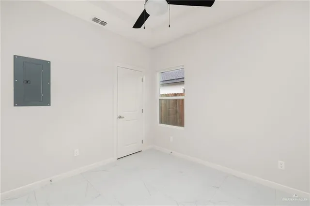 an empty room with a ceiling fan and window