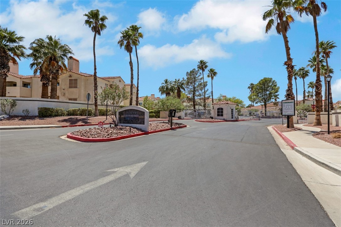 698 South Racetrack Road, Unit 1614 Henderson, NV 89015 - Photo 27 of 35 Palm-lined streets welcome residents to a gated community entrance with inviting architectural details.