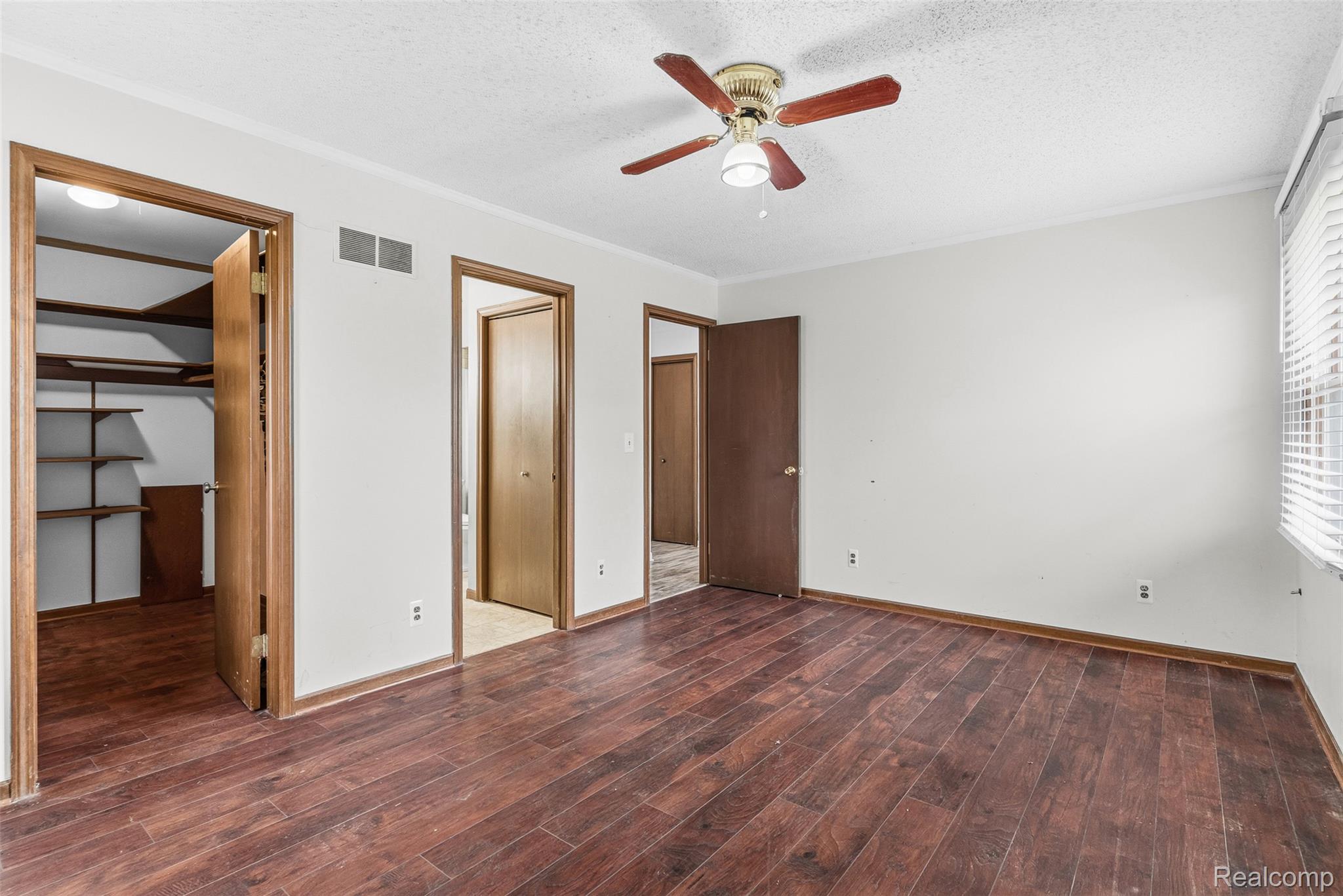 3432 South State Road Davison, MI 48423 - Photo 19 of 58 Unfurnished bedroom with a textured ceiling, dark wood-style floors, a spacious closet, and a ceiling fan
