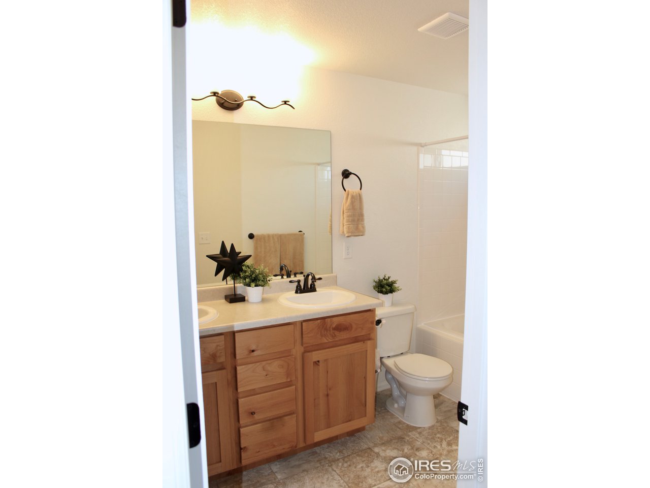 2137 Day Spring Drive Windsor, CO 80550 - Photo 15 of 39 a bathroom with a toilet a sink a mirror a window and vanity
