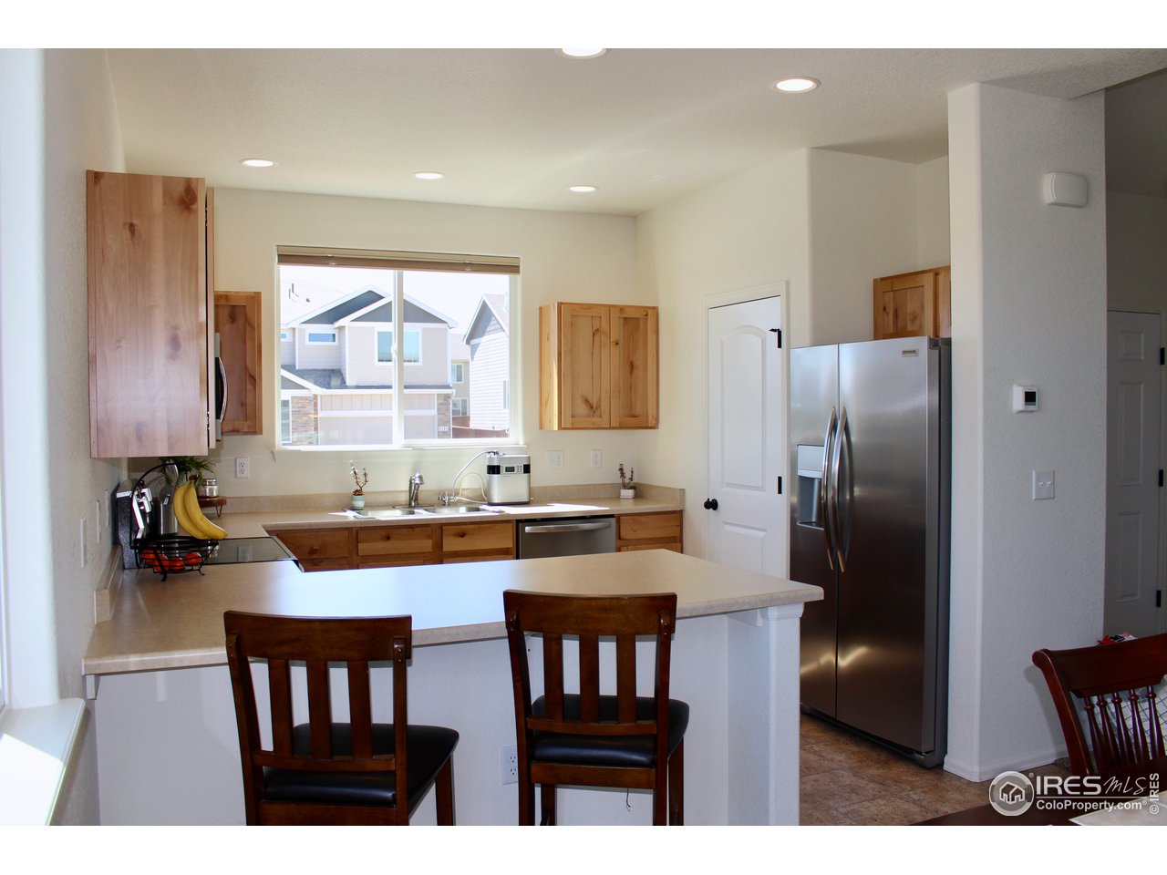 2137 Day Spring Drive Windsor, CO 80550 - Photo 5 of 39 a kitchen with stainless steel appliances granite countertop a table chairs a refrigerator and a sink