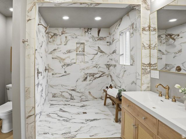 8760 Rustler Road Cottonwood Heights, UT 84093 - Photo 27 of 57 Spacious walk-in shower featuring large format veined tile, a built-in niche, and dual shower heads