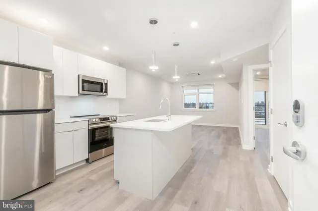 a large kitchen with a stove a refrigerator and a sink