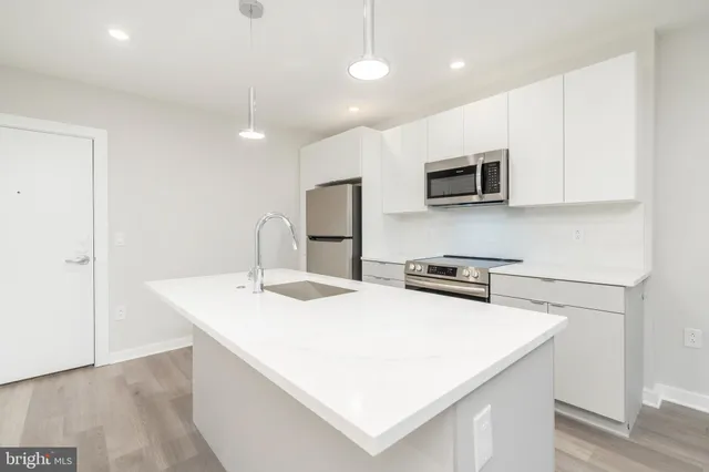 a kitchen with stainless steel appliances a microwave a sink and a refrigerator