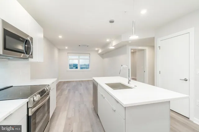 a kitchen with a sink a microwave a stove and refrigerator