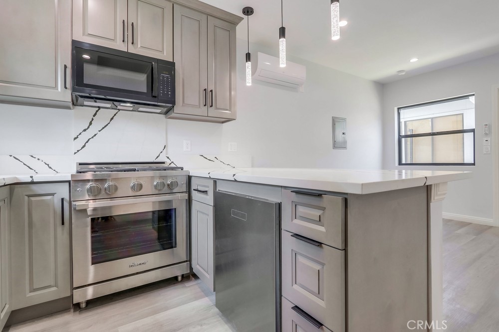 1260 East Turin Avenue, Unit B Anaheim, CA 92805 - Photo 1 of 14 a kitchen with stainless steel appliances a stove microwave and sink