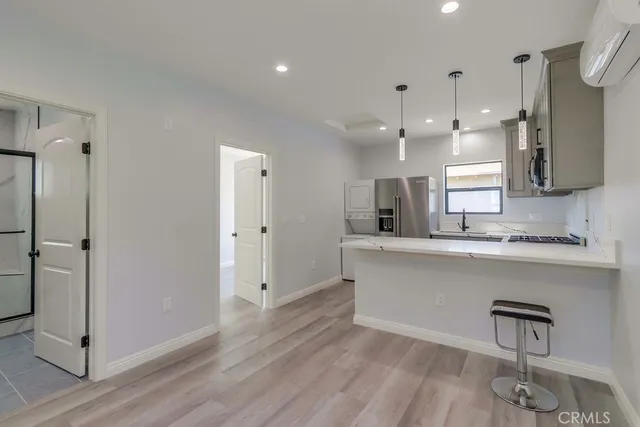 a large white kitchen with a refrigerator a sink stainless steel appliances and cabinets