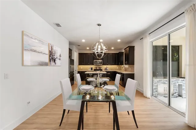 a view of a dining room with furniture a chandelier and wooden floor