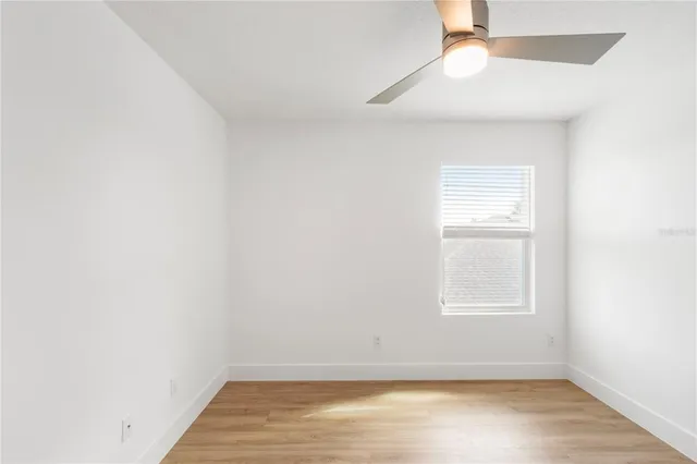an empty room with a window and wooden floor