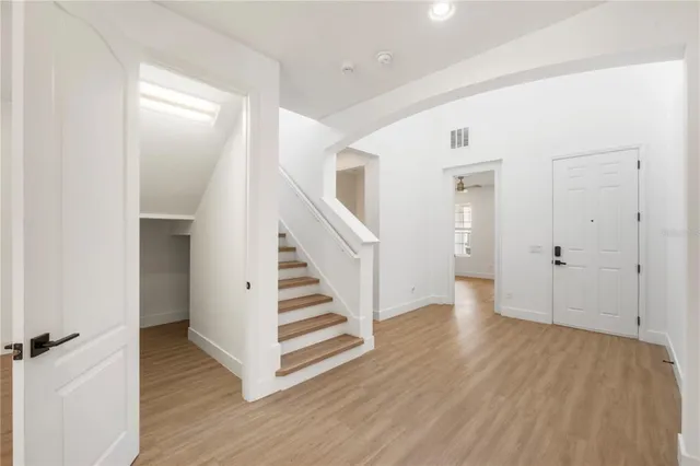 a view of a hallway with wooden floor and entryway