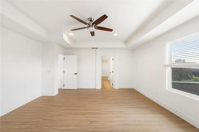 a view of a big room with wooden floor and windows