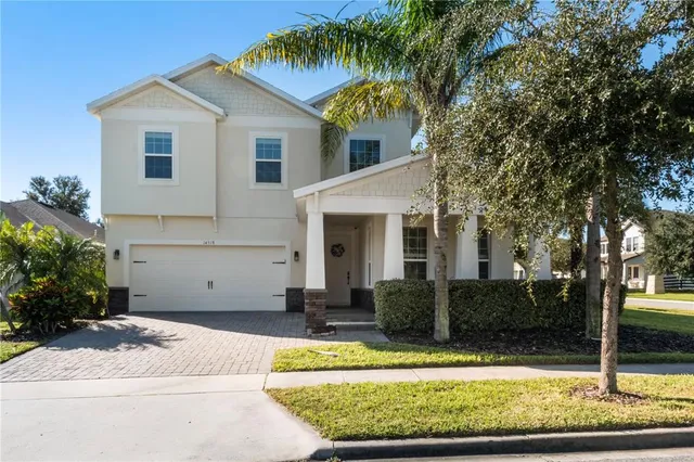 a view of a white house with large windows and a small yard