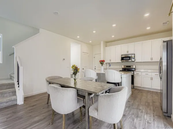 a kitchen with granite countertop kitchen island white cabinets and stainless steel appliances