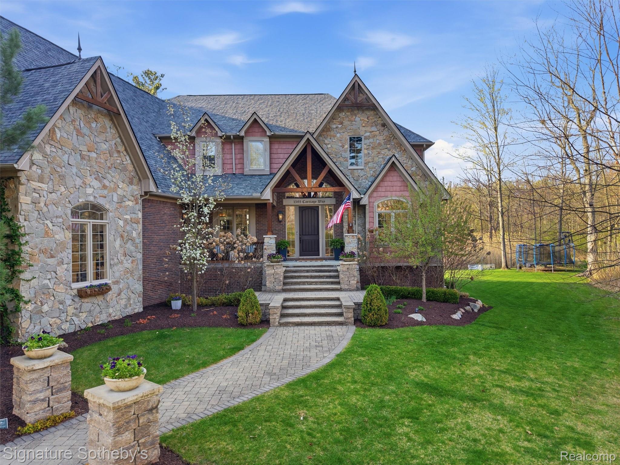 1595 Carriage Way Rochester, MI 48307 - Photo 7 of 78 Craftsman house featuring stone siding, a porch, and a front lawn