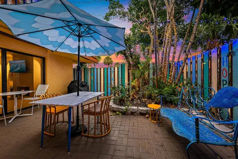 a view of a chairs and table under an umbrella in front of house