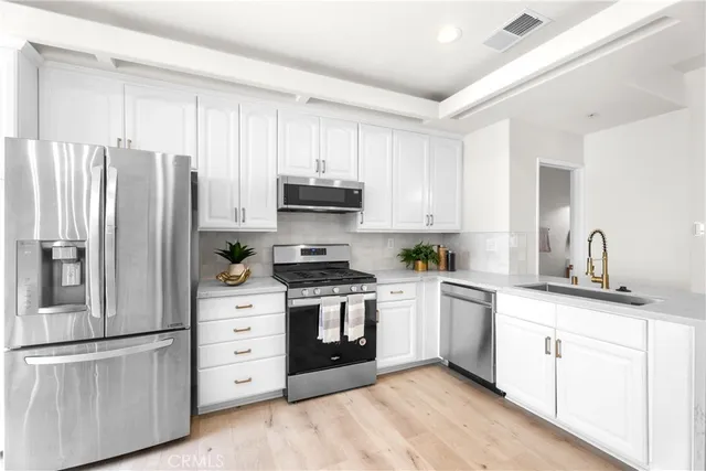 a kitchen with stainless steel appliances granite countertop a refrigerator stove and sink