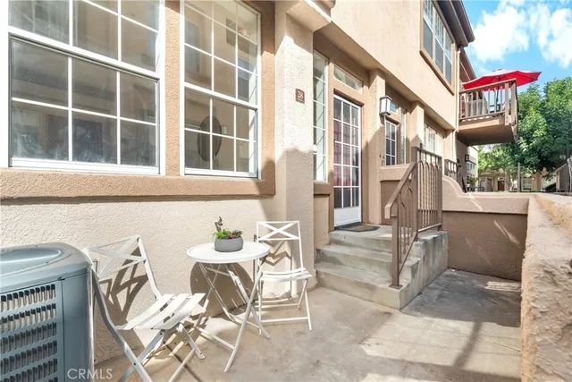 a view of a patio with table and chairs and floor to ceiling window