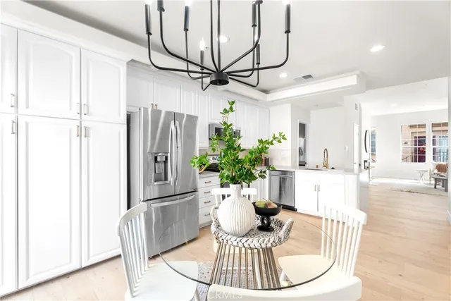a view of a dining room with furniture a potted plant and wooden floor