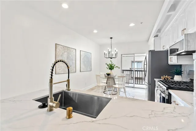 a kitchen with stainless steel appliances kitchen island granite countertop a refrigerator and a sink
