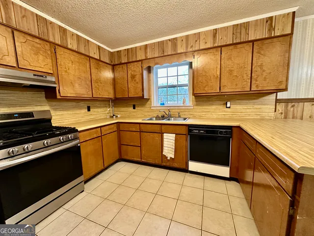 a kitchen with a sink stove and cabinets