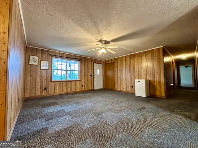 an empty room with windows and cabinet