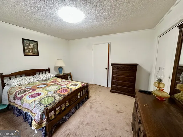 a bedroom with a bed and a view of kitchen