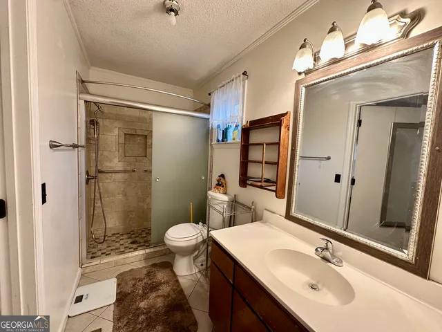a bathroom with a sink toilet a mirror and shower
