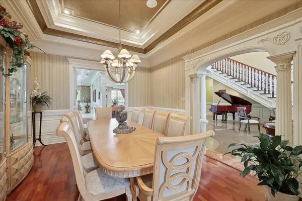 a dining room with furniture a chandelier and wooden floor