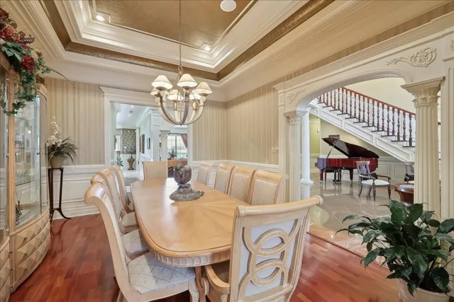 a dining room with furniture a chandelier and wooden floor