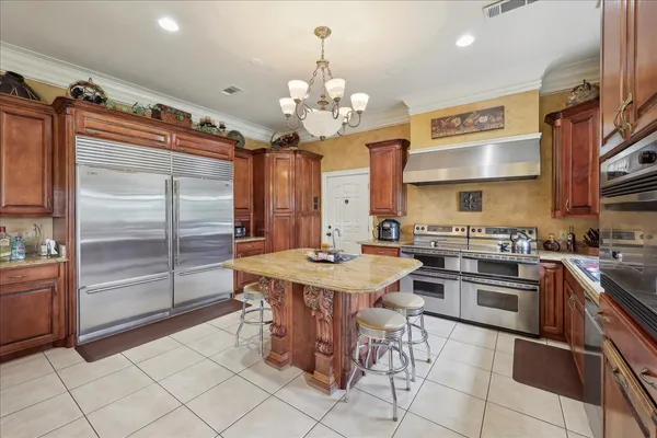 a kitchen with stainless steel appliances granite countertop a sink a stove and a refrigerator