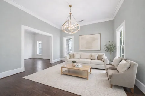 a living room with furniture a window and a flat screen tv
