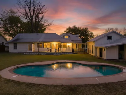 a front view of a house with a yard table and trees