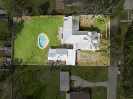an aerial view of a house with a yard basket ball court and outdoor seating