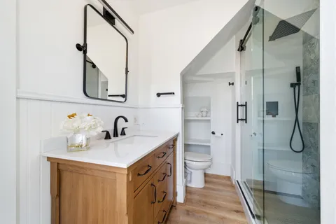 a en suite bathroom with a double vanity sink a mirror and shower