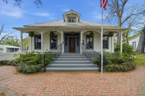a view of a hallway with wooden floor windows and a living room