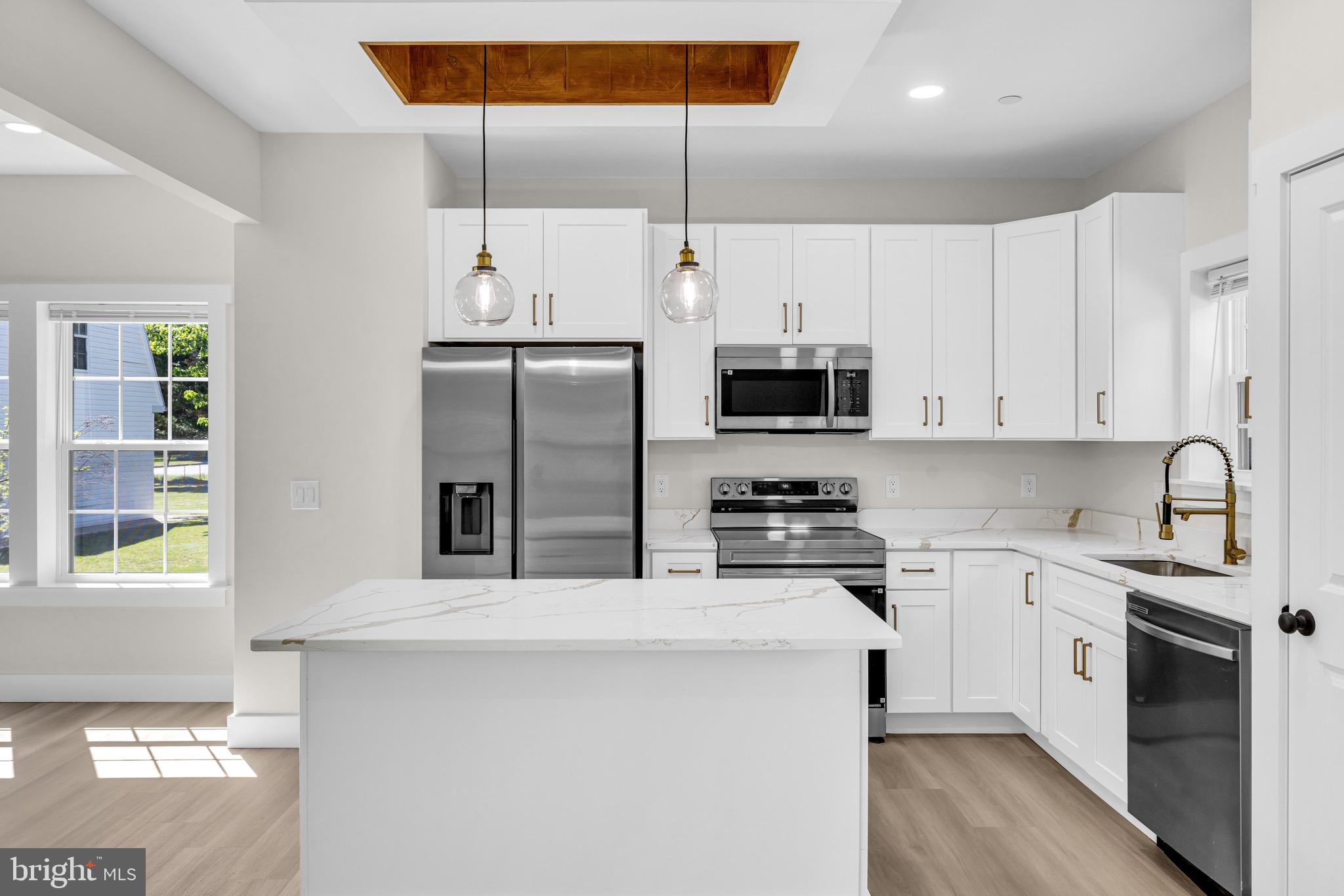 1 Sunrise Avenue Ridgely, MD 21660 - Photo 8 of 28 a kitchen with stainless steel appliances a stove a sink dishwasher a refrigerator and white cabinets with wooden floor