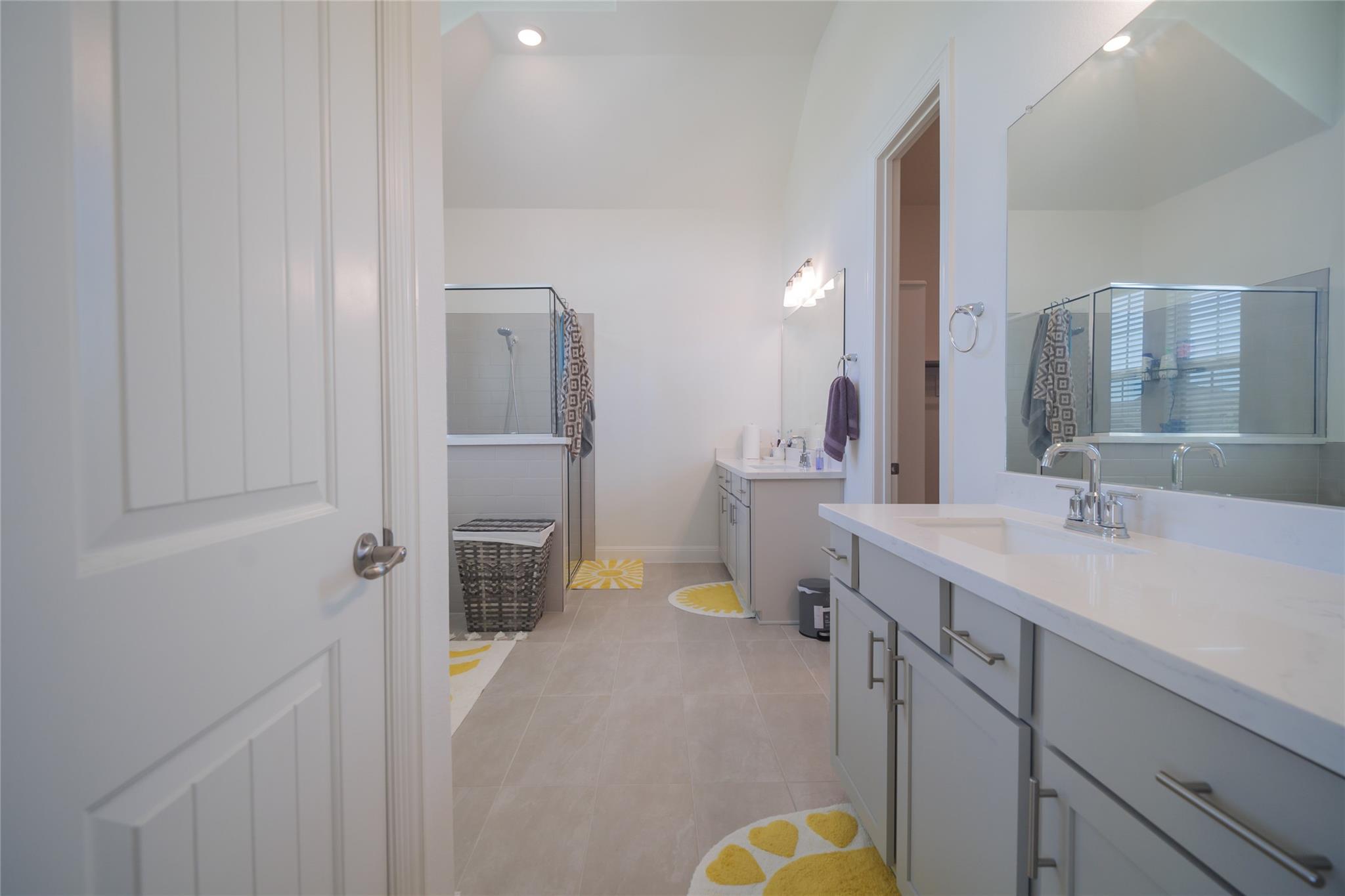 3049 Sage Ranch Drive Leander, TX 78641 - Photo 17 of 23 Clean lines and a spacious layout define this well-appointed bathroom with dual vanities and a walk-in shower.