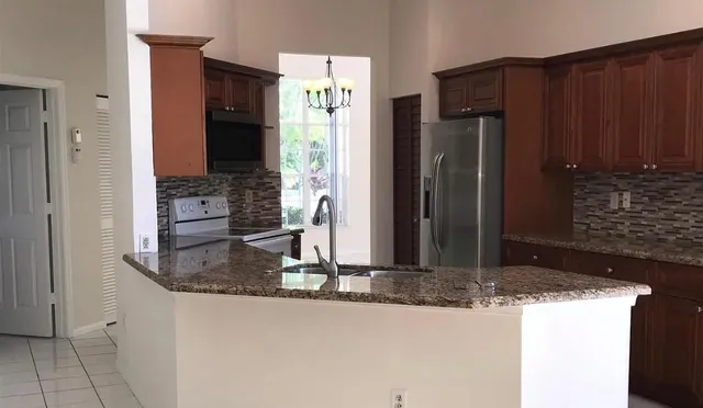 a kitchen with granite countertop a refrigerator and a stove