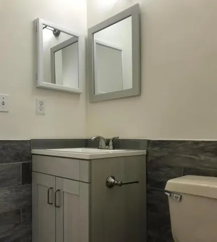 a bathroom with a toilet sink and mirror