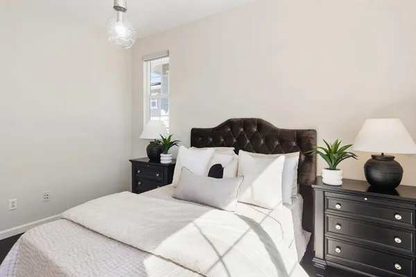 a bedroom with a bed potted plant and a window