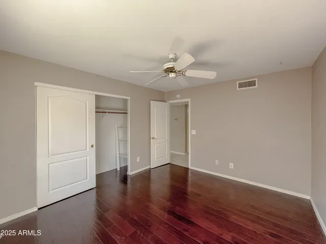 a view of a room with wooden floor and ceiling fan