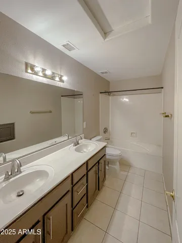 a bathroom with a sink double vanity granite and a mirror