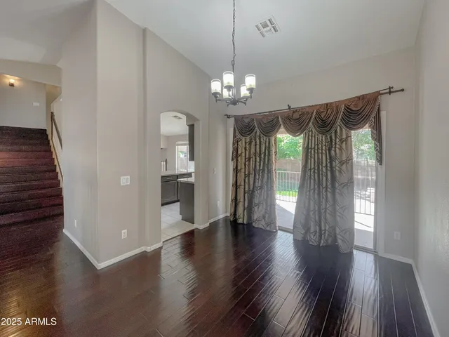 a view of a hallway with wooden floor and a kitchen
