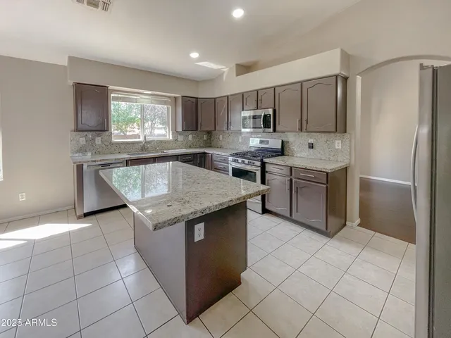 a kitchen with stainless steel appliances granite countertop a sink counter space cabinets and a window